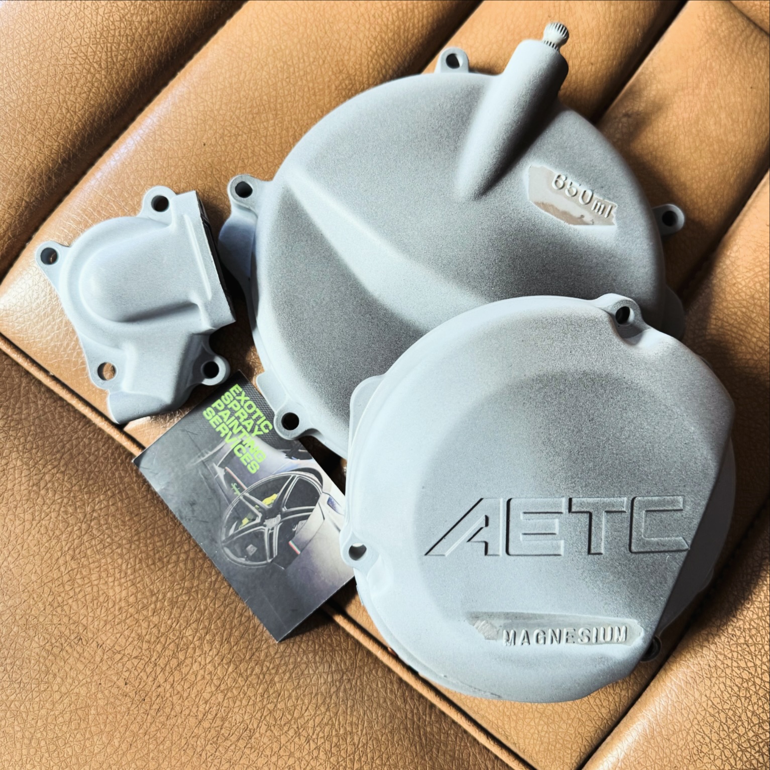 Primed engine and water pump covers sitting on tan leather