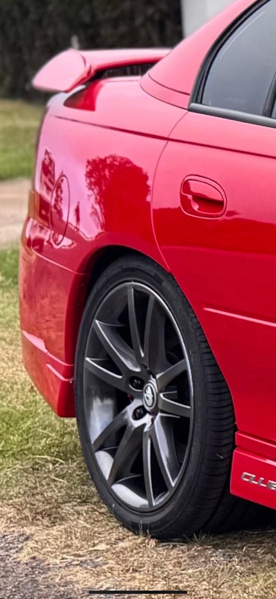 Dark grey alloy wheel on a red sedan